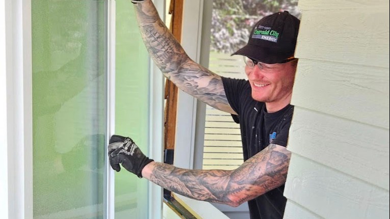 Emerald City Energy installer fitting a replacement window in a Seattle home
